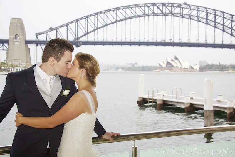 Couple kissing in front of Sydney Harbour - wedding photography sydney